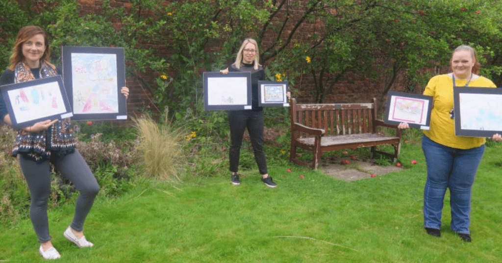 Women holding framed pictures