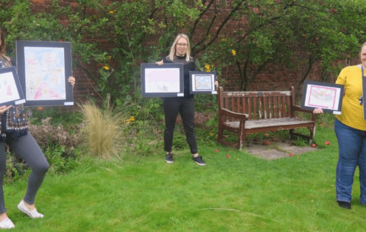 Women holding framed pictures
