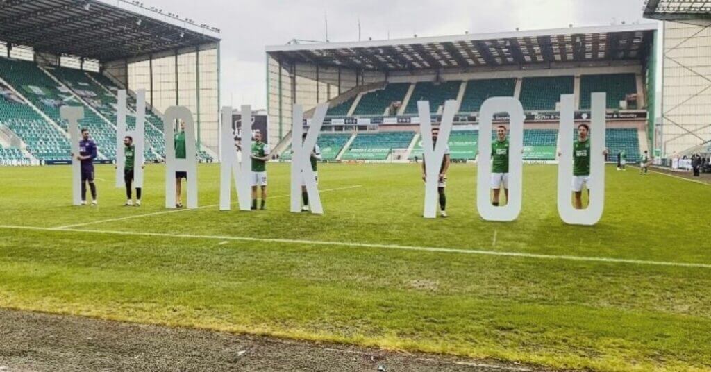 Hibernian FC players holding up Thank You sign