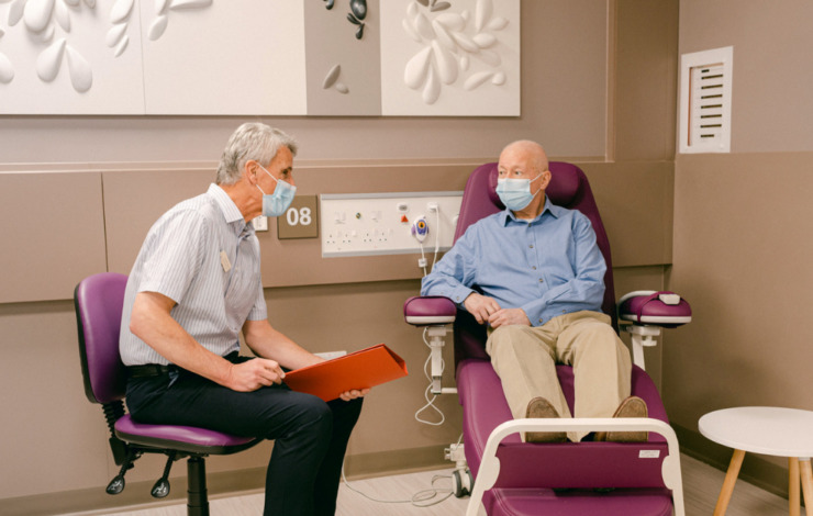 Patient sat in a chair speaking with a doctor