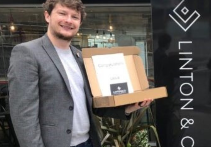 Man holding box of brownies in front of shop