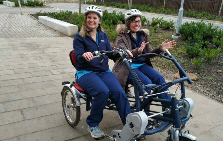 Lothians charity staff riding double bike while smiling