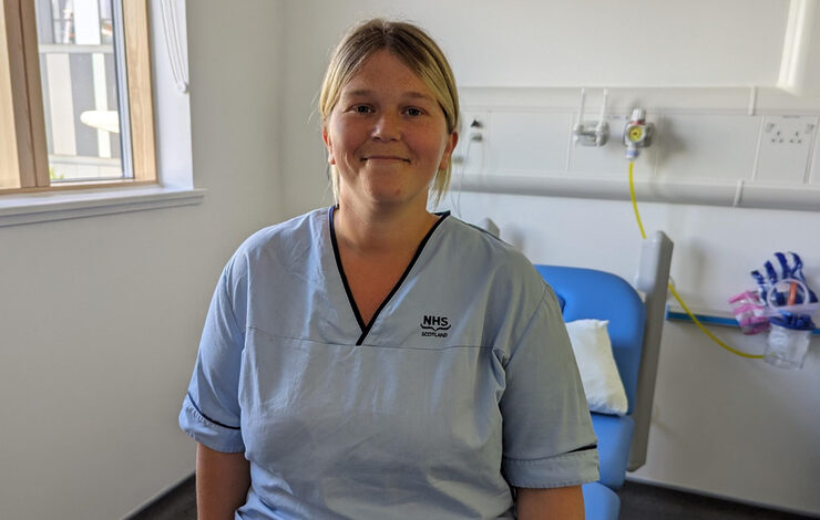 Rachael from the Research Department at RHCYP sat on a bed smiling