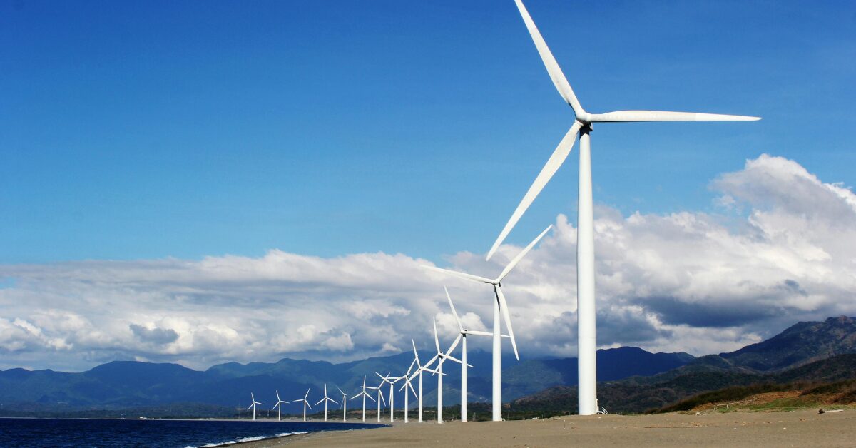 Clean energy wind turbines beside a shore