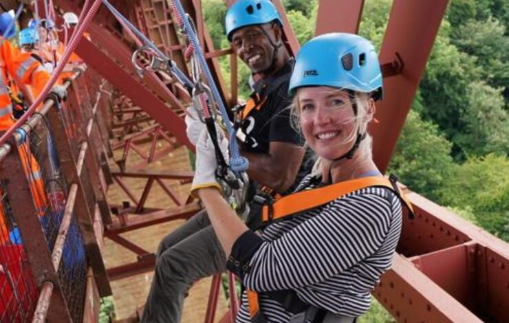a woman and man abseiling down the Forth Rail Bridge