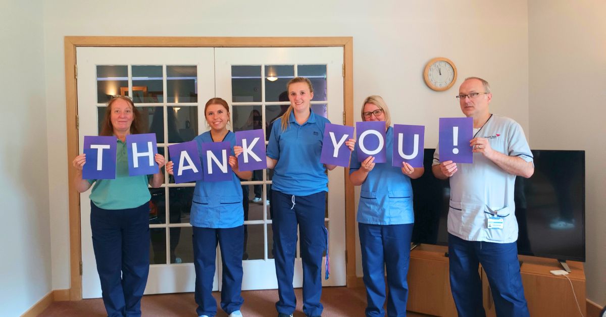 Staff holding up thank you signs
