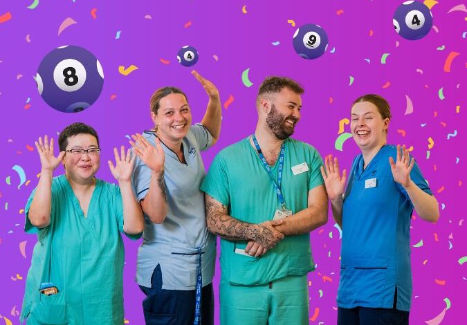 NHS Lothian staff members cheering in front of confetti and lottery balls.